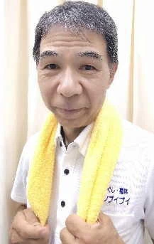 お風呂あがりのイメージタオルを首に掛けている店主