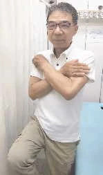 壁のそばで片足立ちをする店主