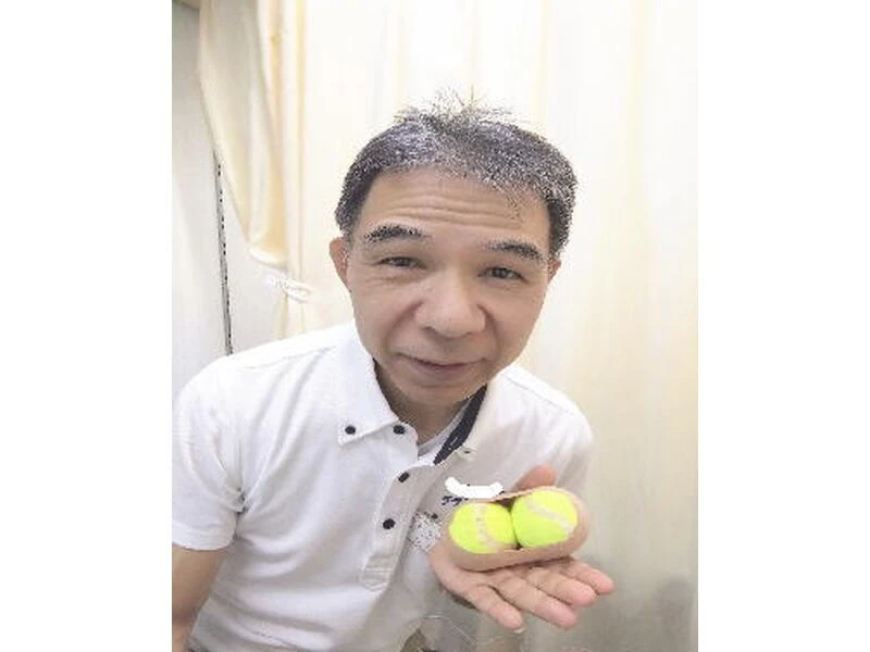 セルフケアに使うテニスボールを2個持った店主
