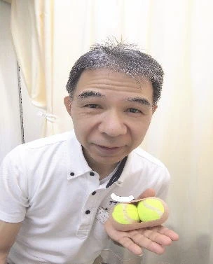 セルフケアに使うテニスボールを2個持った店主