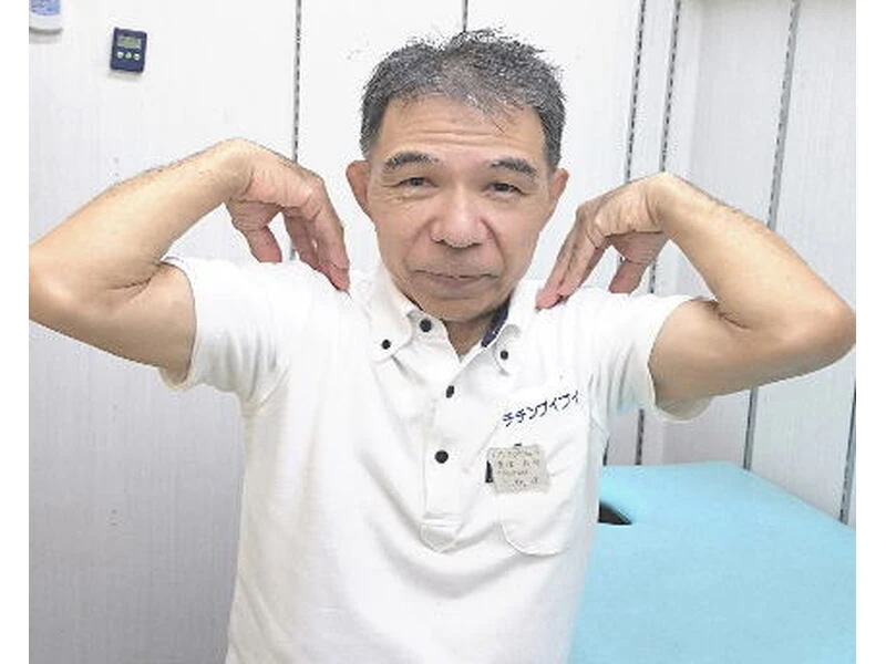 椅子に座って肩まわりのセルフケアを実演するチチンプイプイ店主