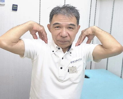 椅子に座って肩まわりのセルフケアを実演するチチンプイプイ店主